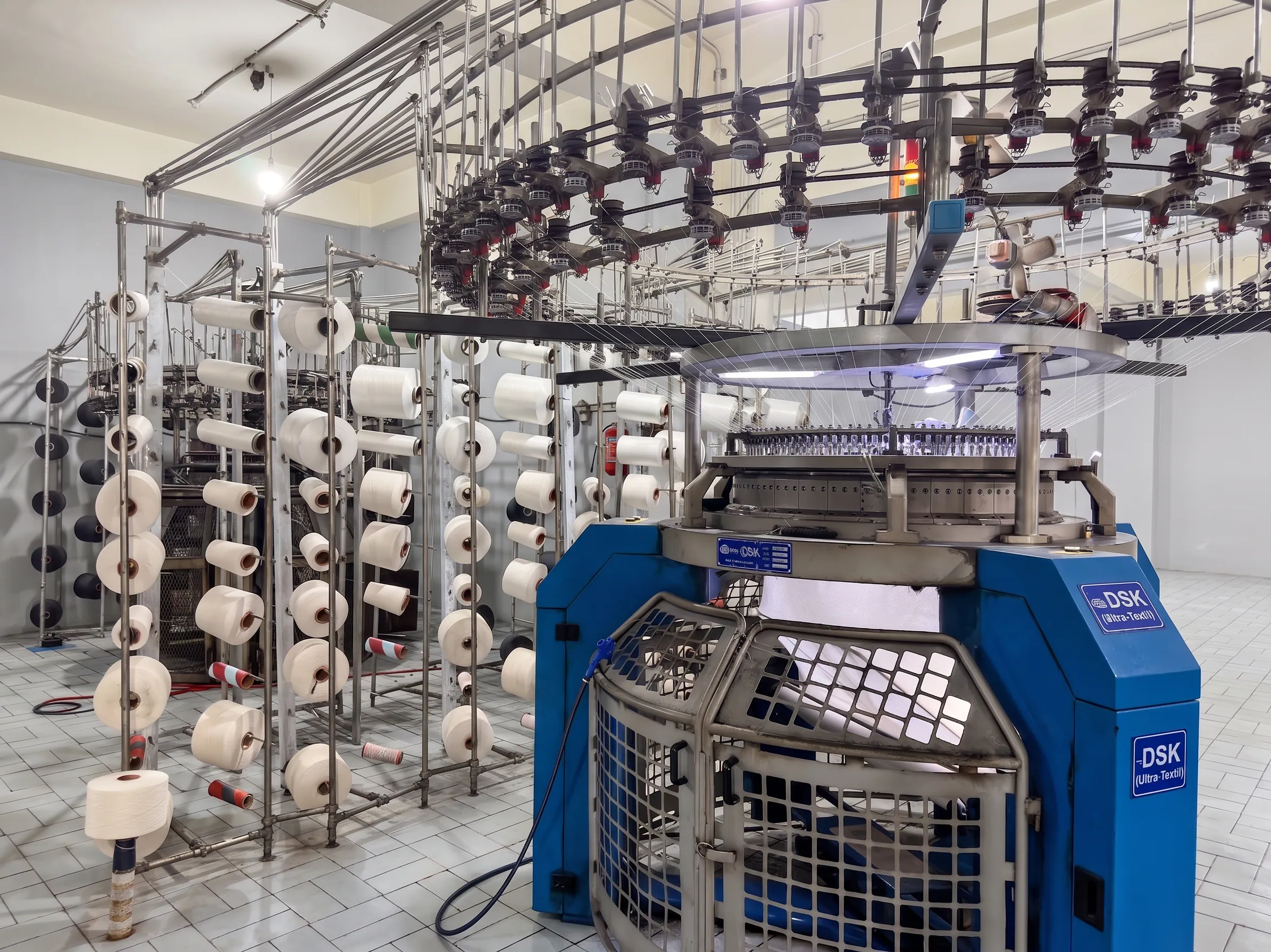 Industrial circular knitting machine producing grey knitted fabric at Apex Corporation manufacturing plant in North Karachi Industrial Area Pakistan